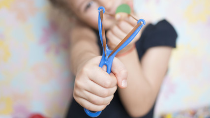 girl shoots with a slingshot