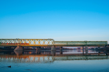 Fototapeta na wymiar Train and railway bridge in the early cold sunny morning.