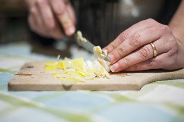 woman's hands cut vegetables on chopping board