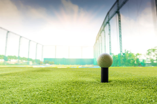 Close Up golf ball on tee in modern Golf course driving range.	