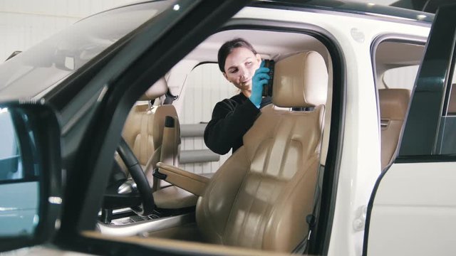 Car cleaning - attractive young woman is washing interiot of a luxury vehicle