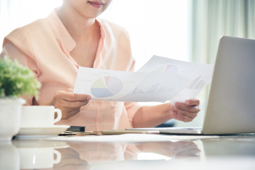 Businesswoman holding graphs and business chart diagram documents.