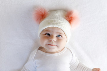 Cute adorable baby child with warm white and pink hat with cute bobbles