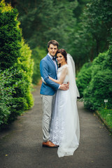 Pretty wedding couple poses in a green spring garden