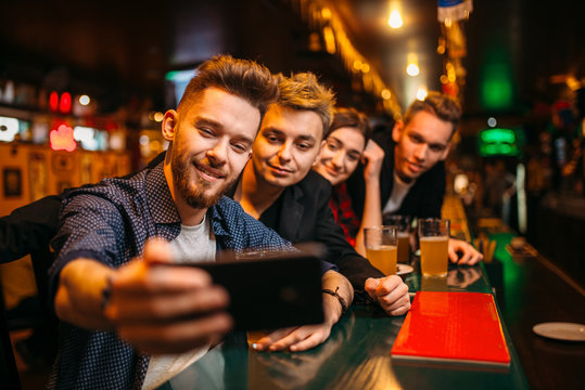 Happy football fans makes selfie at bar counter