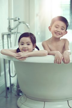 The lovely boy and girl are in the bathtub