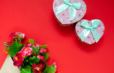 Valentine's day gift for the second half, a bouquet of flowers, a romantic photo, a cardboard pink heart bow on a red background, background suitable for advertisement , insert text