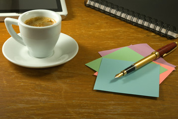  cup of coffee, stationery, keyboard and tablet on the table closeup