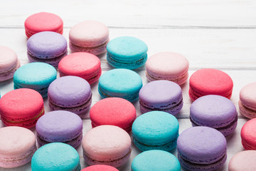 Close up colorful macarons dessert on a wooden table. Sweet french macaroons background.