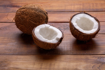 Coconut cut in half on color wooden table background