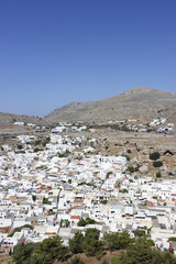 Small white houses on the mountains and blue sky background.