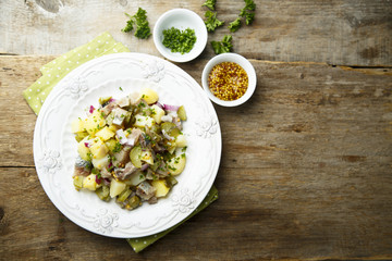 Potato salad with herring, onion and cucumber