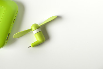 A flat lay of a green mini fan to a power bank