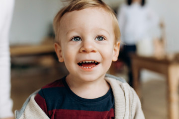 Charming little boy in a nice hoodie plays in the room