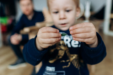 Little boy looks curious playing with greenery