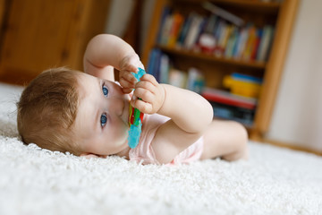 Adorable baby girl playing with educational toys in nursery