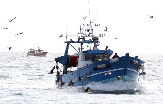 Fototapeta chalutiers en mer pris à contre-jour