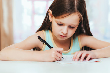 the girl is a first grader in the room doing homework