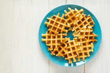 Homemade Belgian waffles on blue plate. Selective focus