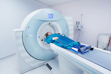 Female patient undergoing CT - Computerized Tomography Scan in Hospital. Patient wearing lead apron to   cover vital organs.