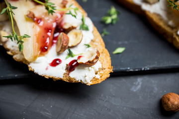 Bread with ricotta cheese and pears on the wooden background. Shallow depth of field.
