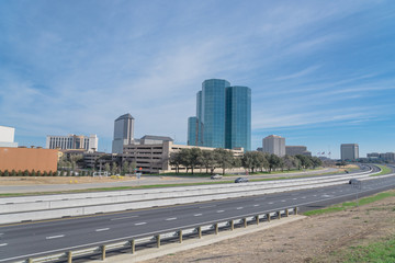 Irving, Texas skyline view from John Carpenter Freeway under winter cloud blue sky. Cityscape and transportation background. © trongnguyen
