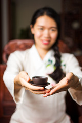 Woman offering traditionally prepared Chinese tea