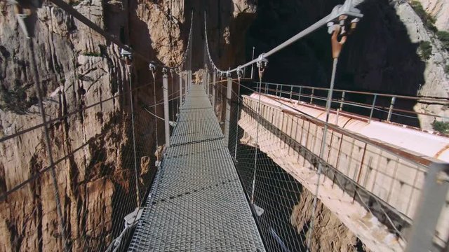 Beautiful exciting and scary hanging suspension bridge over abyss on high height between rocks and cliffs. One of most popular places to visit in 2018 around world