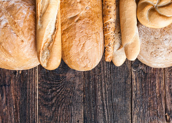 Delicious fresh bread on wooden background