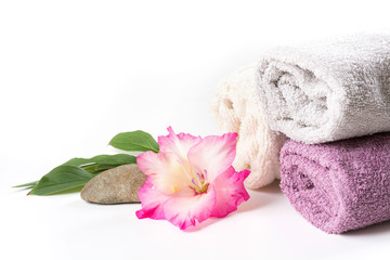 Spa setting of towel, flower, coffee on white. Copy space. Relax. Close up.