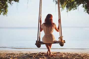 relaxation, woman on beach swing - obrazy, fototapety, plakaty