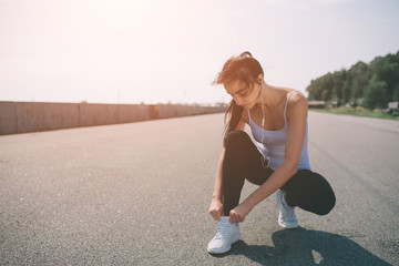 Beautiful woman running during sunset. Young fitness model near seaside. Dressed in sportswear. Cords sneakers.
