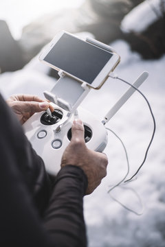 Man flying drone in snowy landscape.