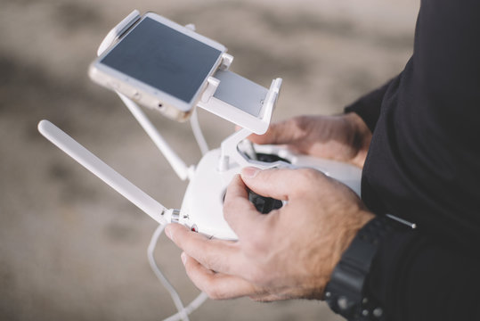 Close-up of man holding remote control of drone