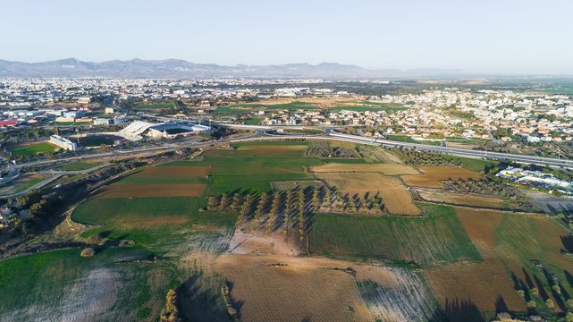 Aerial bird's eye view of GSP football stadium, highway A1 at Latsia, Nicosia, Cyprus. The soccer field, athlete track, seats and auxiliary pitch of Pancyprian Gymnastic Association Stadium from above