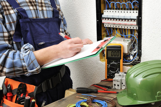 Young electrician technician at work on a electrical panel