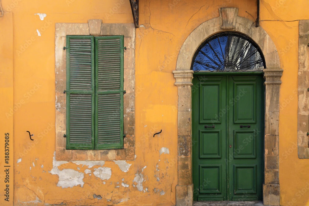 Sticker old green door and window of ancient yellow building