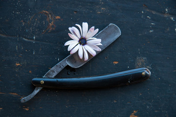 Grunge razor with flowers on the old black background