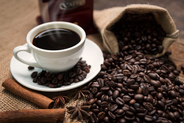 Closeup of coffee beans and bag on wooden table
