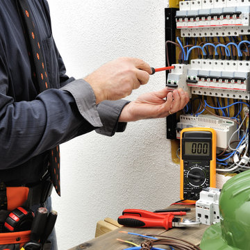 Elegant electrician technician at work on a residential electric panel
