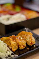 The cup of salad with various such as cabbage carrot lettuce etc with the dish of steak and bowl of rice , focus on only salad bowl and blur background object intendly.