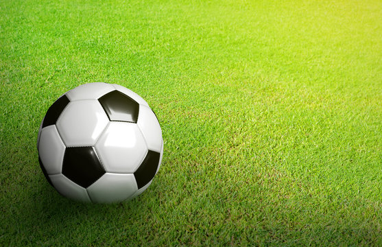 3D Rendered black and white soccer ball on green soccer football field background