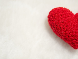 half of handmade red yarn heart on white wool. the red heart on the right of picture and background copy space for text. Valentines day, love concept and love background