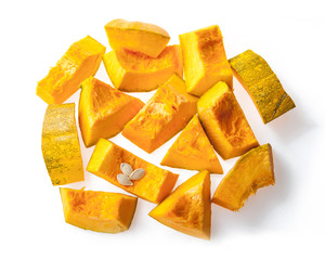 raw sliced pumpkin chunks with seeds on white background