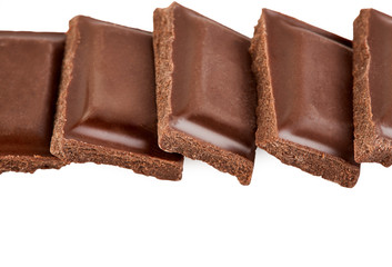 Milk chocolate pieces isolated on white background.
