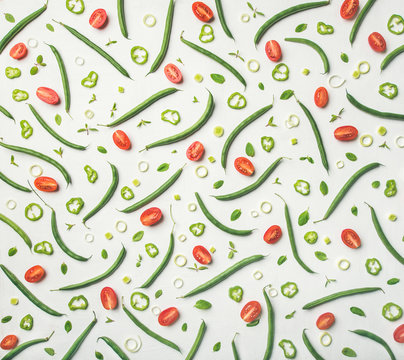 Food pattern, texture and background. Flat-lay of fresh green beans and cherry tomatoes over white wooden background, top view. Healthy cooking, clean eating, vegan, vegetarian, dieting concept