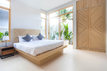 Luxury Interior design in bedroom of pool villa with cozy king bed. Bedroom with high raised...