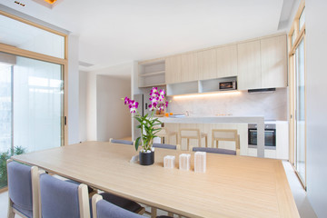 Luxury interior design in living room of pool villas. Airy and bright space with high raised ceiling and wooden dining table