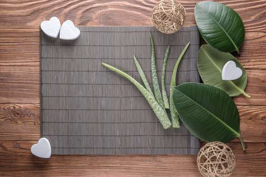 Aloe vera leaves on wooden table. Natural cosmetic ingredients with copy space. Fresh aloe vera plant on wooden board, flat lay. Spa concept, top view.