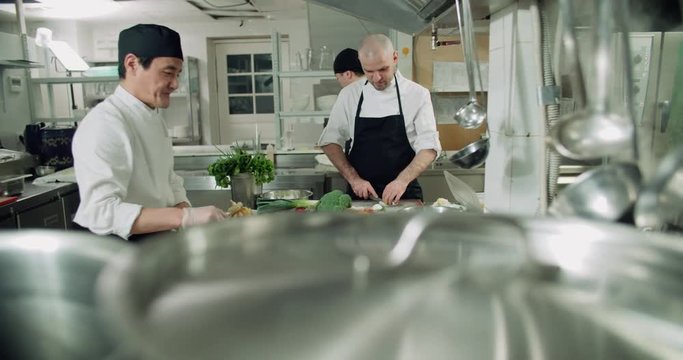 the workflow in the kitchen of the restaurant,a team of Asian chefs prepare dishes